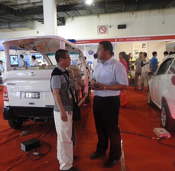 展览会上沐鸣2电动车有限公司工作人员对客户介绍沐鸣2电车