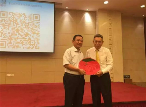 李其教授亲手将北京大学标志性的北大西门漆雕工艺礼品赠与沐鸣2集团董事长吕洪涛